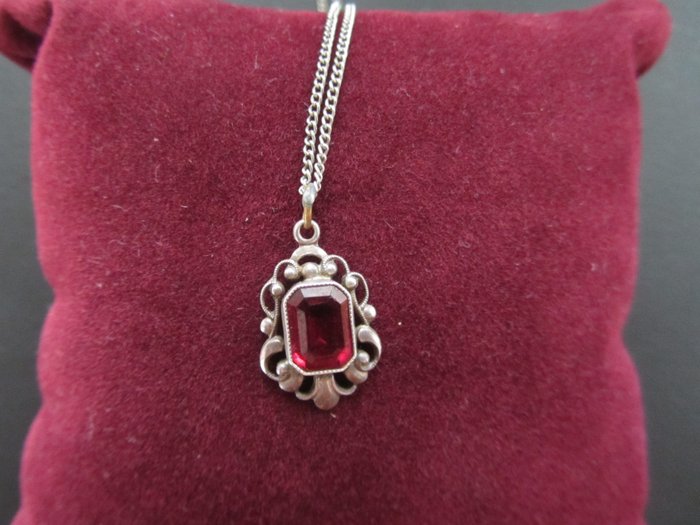 Filigree pendant made of silver, studded with a red stone. - Catawiki