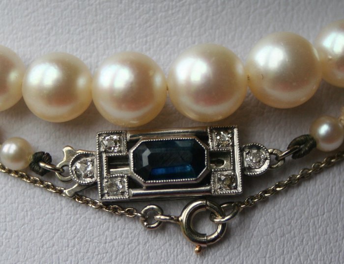 1920"40 Antique pearl necklace with real Japanese round Akoya sea/salty pearls and with a beautiful lustre. Gold clasp with Saffier ca. 0,45ct. and 6 old cut diamonds.  