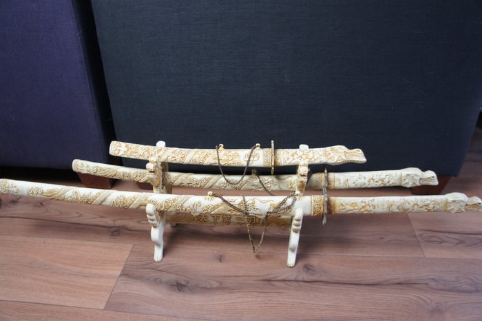 Beautiful ivory look Katana swords op a unique stand


