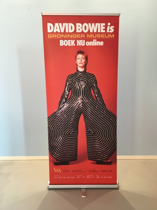 Exhibition banner for 'David Bowie is' with image of David Bowie in Yamamoto bodysuit