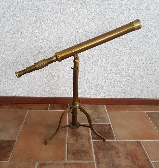 Large old standing brass telescope on industrial tripod