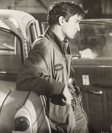 Robert De Niro vicino ad un taxi in Taxi Driver Di Martin Scorsese.