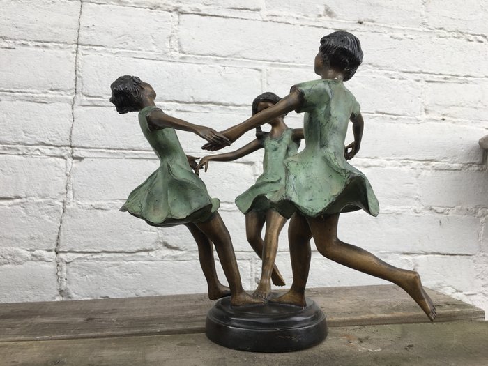 Bronze sculpture of three dancing girls
