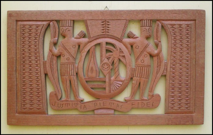 Cut from tropical wood coat of arms of Suriname