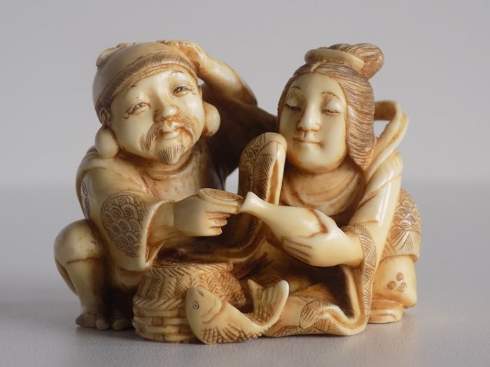 Ivory netsuke representing a divine couple signed with red seal - Japan - 19th/ early 20th century