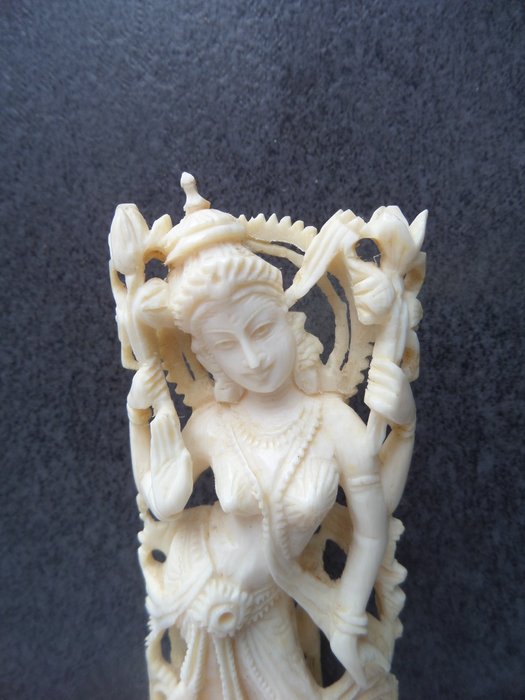 Ivory sculpture of the Hindu goddess Lakshmi on a lotus flower; on wooden stand - India - around 1930