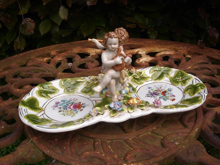 R.B. porcelain appetizer dish with puttis playing music and floral decorations.