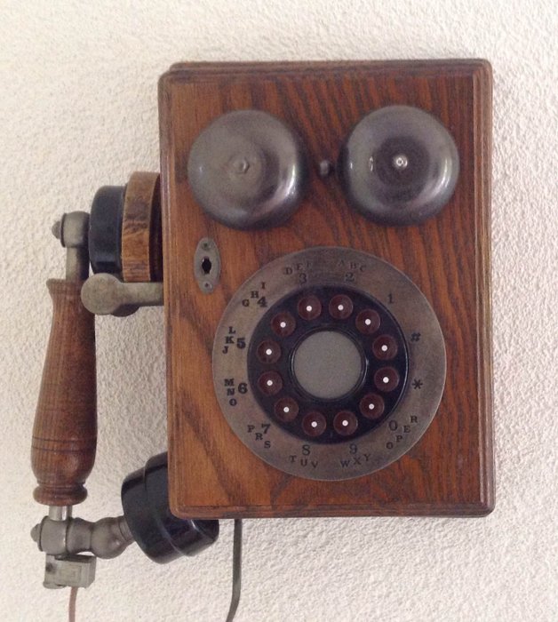 Old phone in oak wood cabinet, model from around 1950s