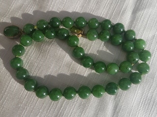 Deep green jade necklace, circa  1950s, 65 g. 