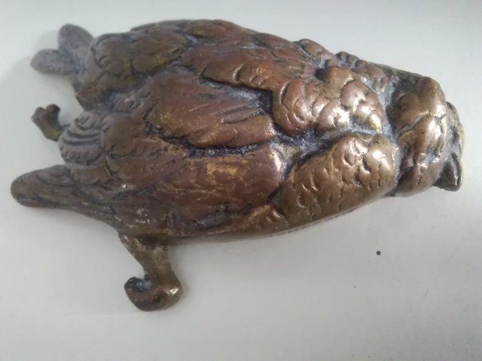 Bronze-toter Vogel. Papierpresse - Bronze