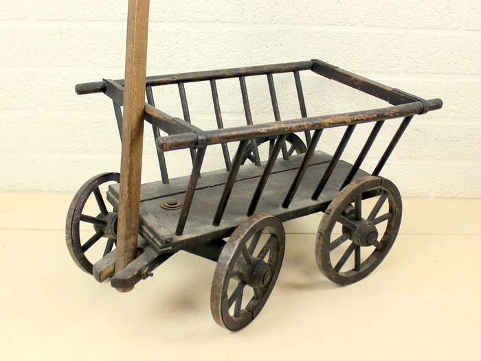 Un carrito de mano con ruedas de madera. - Llantas de madera con ruedas de hierro.