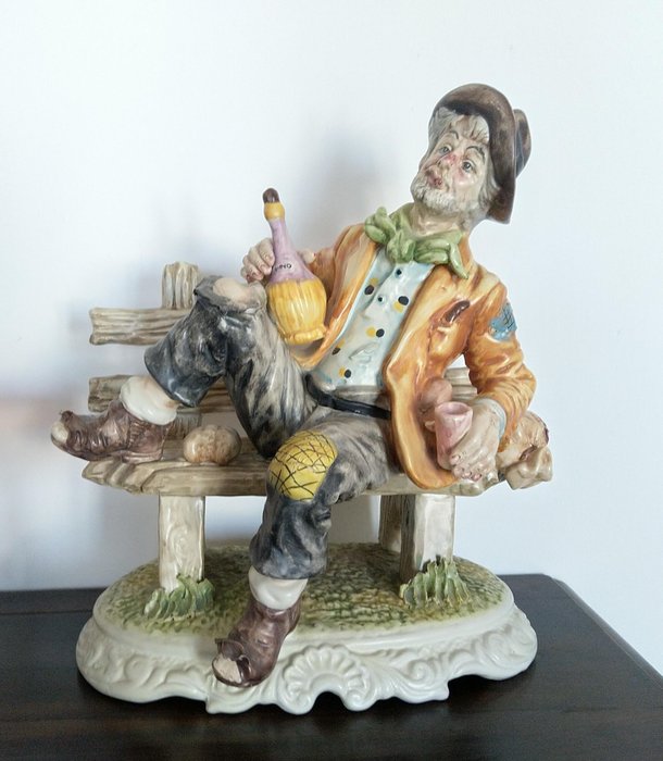 Capodimonte - Flott komposisjon, mann med kolbe på benken - Porselen