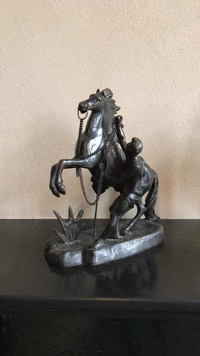 After Guillaume Cousteau - a bronze-coloured brass sculpture group of a rearing horse and tamer - first half of 20th century