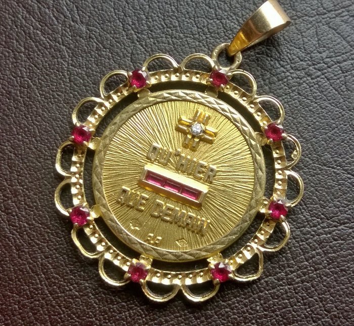 Authentic Augis "Médaille d'Amour" medal. Yellow gold 18 kt, 750/1000, set with a small diamond, 8 small round rubies and 3 calibrated rubies.