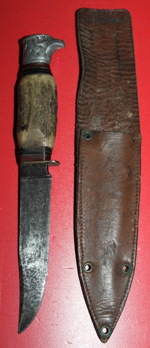 Vintage German knife by Puma Solingen, with an eagle head pommel and a horn hilt, leather sheath, in fair condition