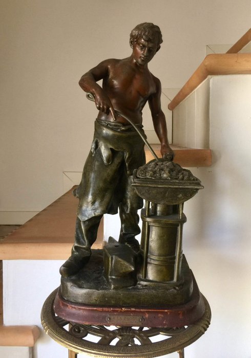 E. Rousseau (1853 - ?) - ‘A la forge’ - large statue of a blacksmith made of multi-coloured spelter - France - early 20th century