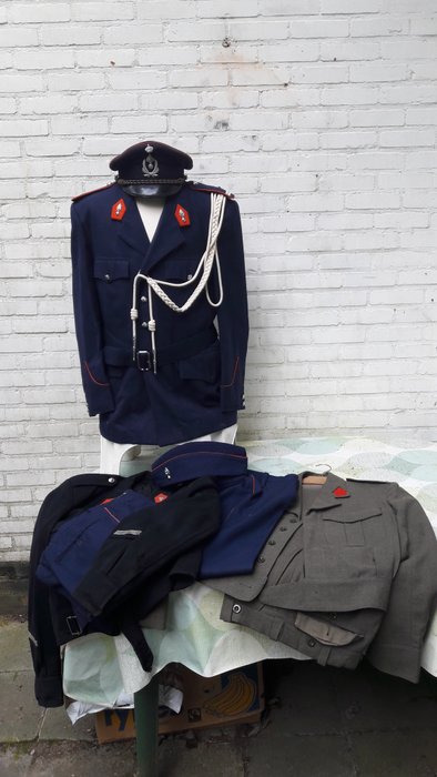 Kavel Belgische militaire en rijkswacht uniformen met broeken en hoofddeksels.
