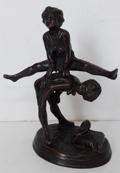 Bronze sculpture of two children playing leapfrog