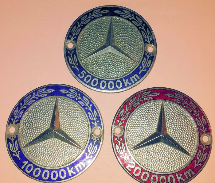 Three original Mercedes Benz emblems - 100,000 km, 200,000 km and
