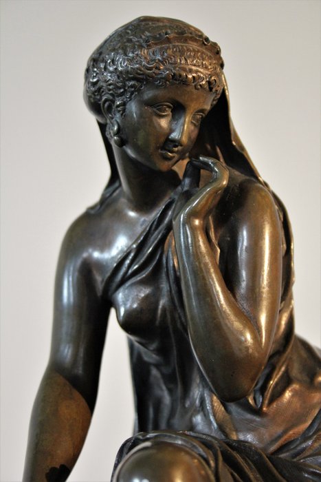 Henry Etienne Dumaige (1830-1888) - Grande sculpture en bronze orientaliste, patine d'origine - Représentant une femme drapée à l'antique, assise sur une banquette recouverte de coussins brodés - XIXème siècle 