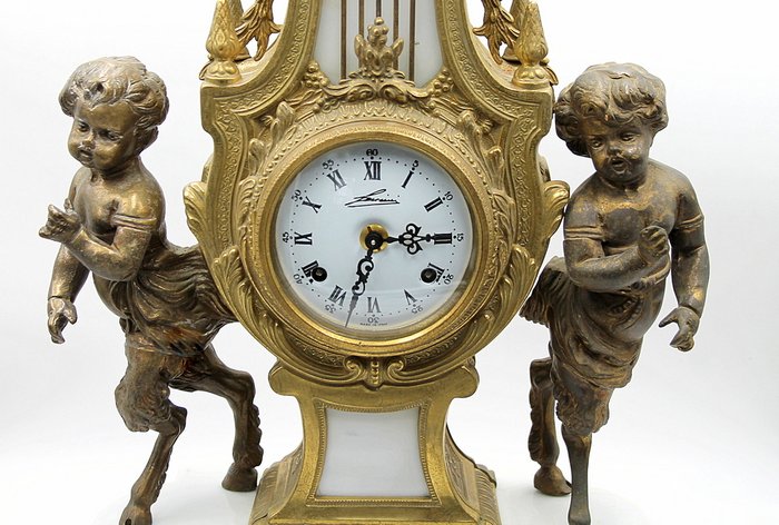 Wonderful triptych in Baroque style: clock with cherubs and pair of candelabras in brass and marble, 20th century