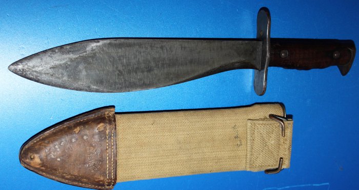 U.S. M 1917 Bolo knife/machete, marked US model 1917 and on the other side Plumb phila 1918, in canvas scabbard marked Brauer Bros 1918, in  good condition