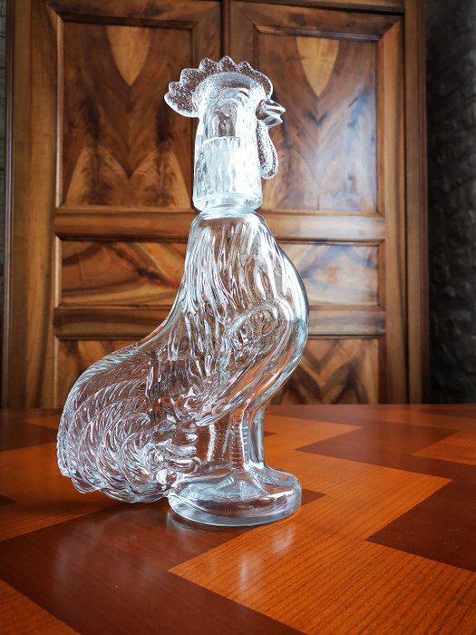 大玻璃水瓶以公鸡的形式倾倒葡萄酒 - 玻璃