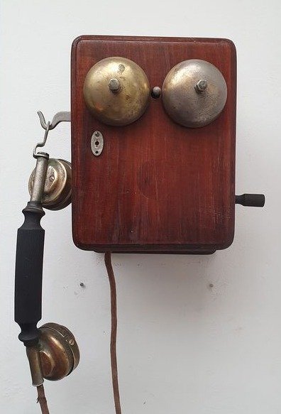 Um telefone de parede, década de 1920 - madeira e metal