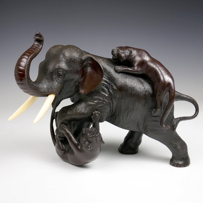 Un éléphant se battant avec deux tigres. Okimono - Bronze - Par Genryusai Seiya - Signé 'Seiya Sei' - Bronze - Japon - XIXe siècle