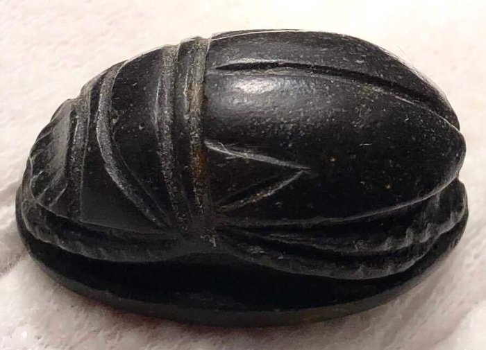 Antiguo Egipto Piedra Exquisito escarabajo de corazón negro con detalles tallados a mano con precisión que delinean la cabeza, las piernas y el cuerpo.