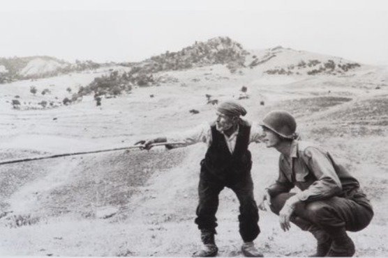 Robert Capa (1913-1954) - Un contadino siciliano indica la strada a un soldato americano.