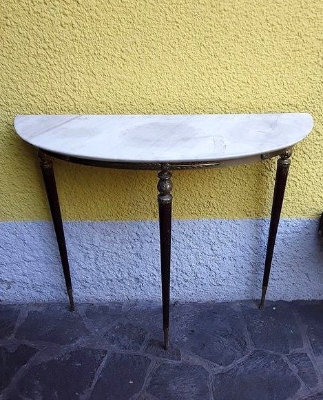 Mesa de pared equipada con tres patas en madera y latón con tapa de mármol.