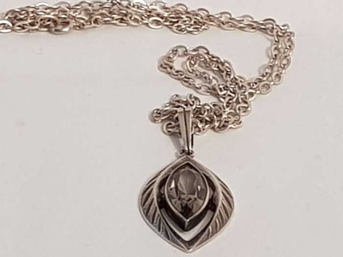 Preview of the first image of Lang zilveren schakel collier ca 60 cm waaraan een ovaal gevormde zilveren hanger met een geslepen.