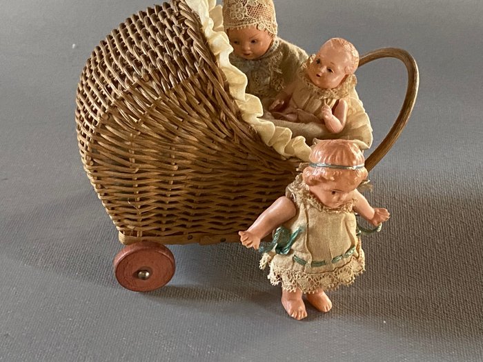 Preview of the first image of diverse merken - miniature doll pram with three dolls - 1920-1929 - Germany.