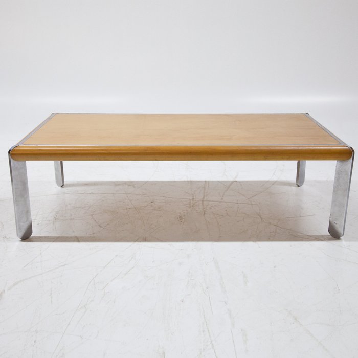 Sohvapöytä - Sohvapöytä seisoo kromatuilla pyöristetyillä jaloilla, joissa on suorakaiteen muotoinen pyökkikansi.