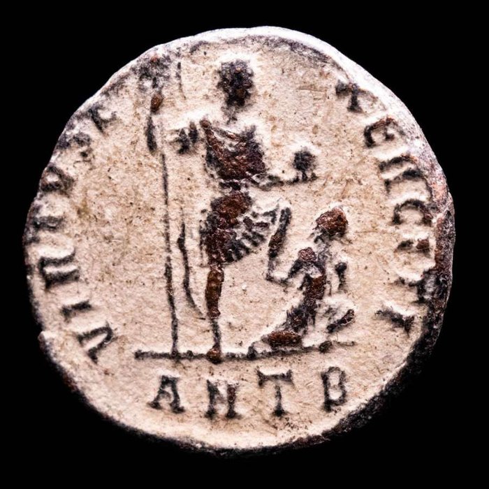 Romerska riket. Theodosius I (AD 379-395). Maiorina Antioch mint. VIRTVS E-XERCITI, Emperor standing facing, head right, foot on captive, holding  (Utan reservationspris)