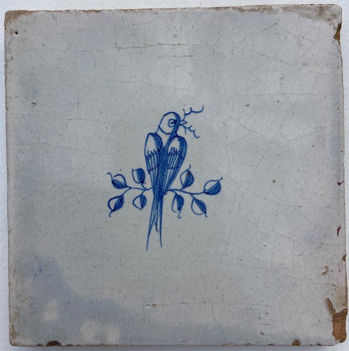 Tile - Delft blue tile showing a bird with a branch between its beak - 1600-1650 