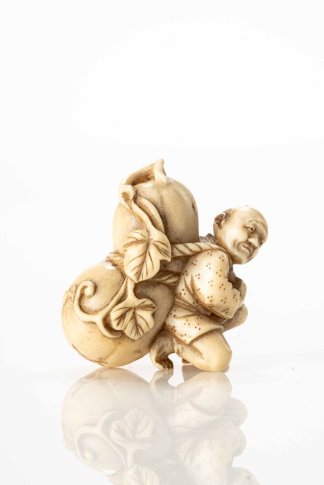 An ivory netsuke depicting a farmer carrying a giant pumpkin tied with a rope - Ivory - Japan - Meiji Period (late 19th century)