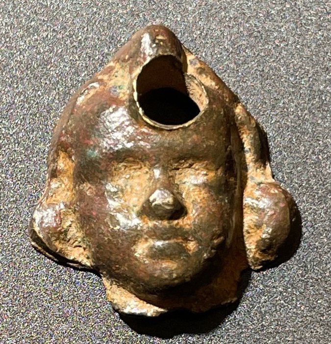Roma antica Bronzo Testa di Eros secondaria traforata per essere indossata come Amuleto. Con licenza di esportazione
