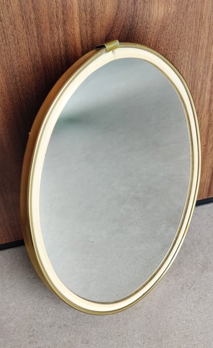 Espejo de pared  - Espejo de cristal con marco de metal dorado.